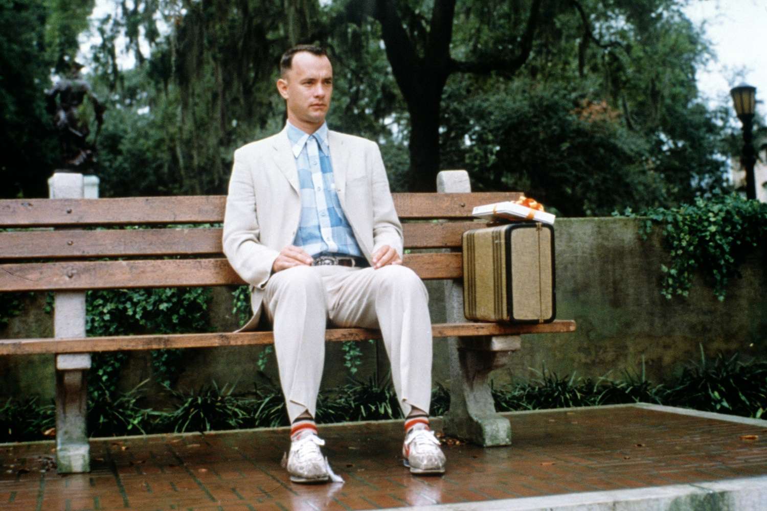 Een foto van een scène uit de film Forrest Gump.  Het titulaire personage zit op een bankje.