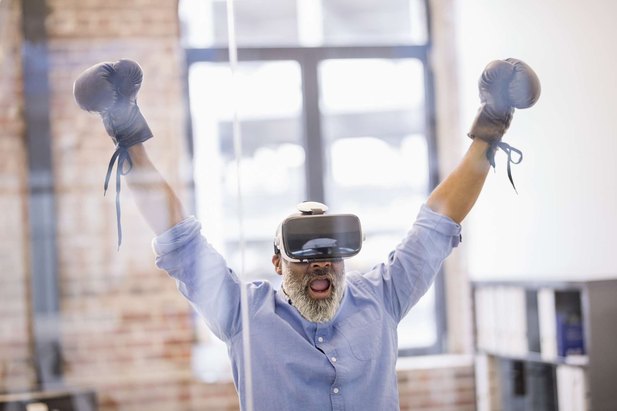 Zakenman met Virtual Reality-bril en bokshandschoenen op kantoor