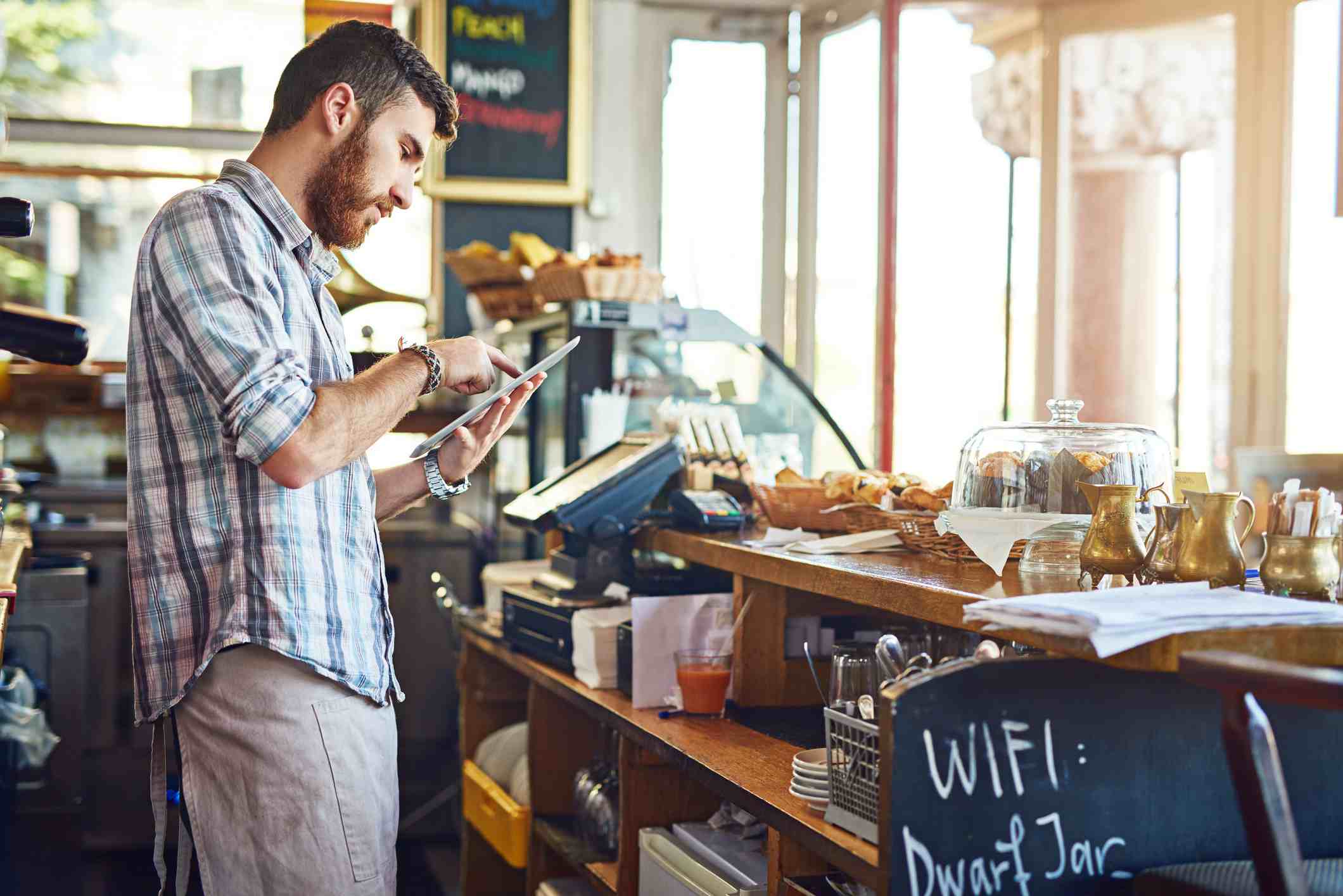Man aan het werk in coffeeshop met iPad