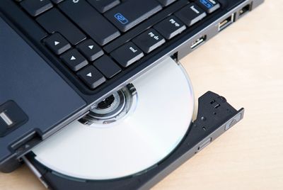 Foto van een cd of dvd die wordt uitgeworpen uit een laptop