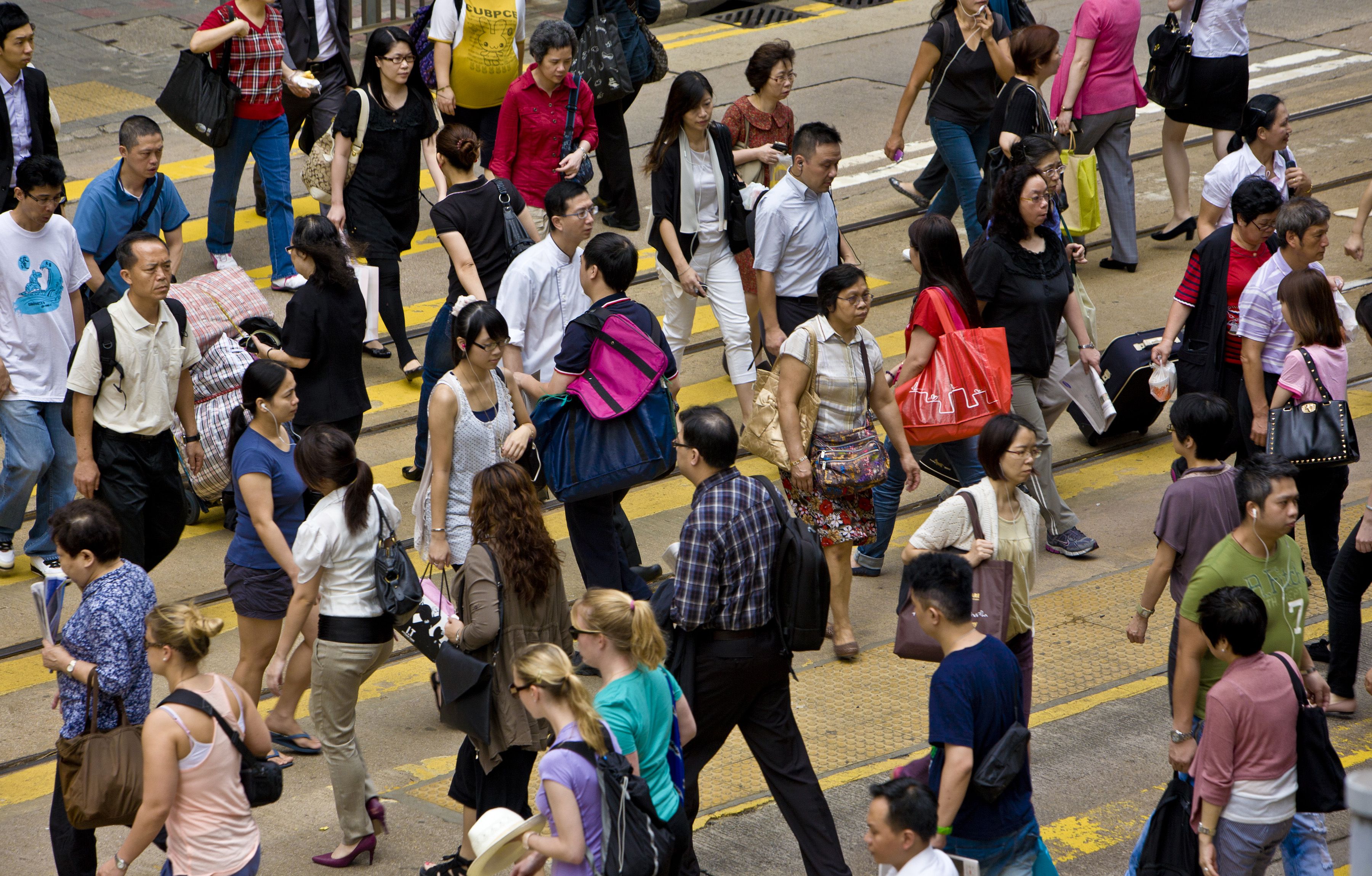 Een foto van een menigte mensen die de straat oversteken in Hong Kong, China.