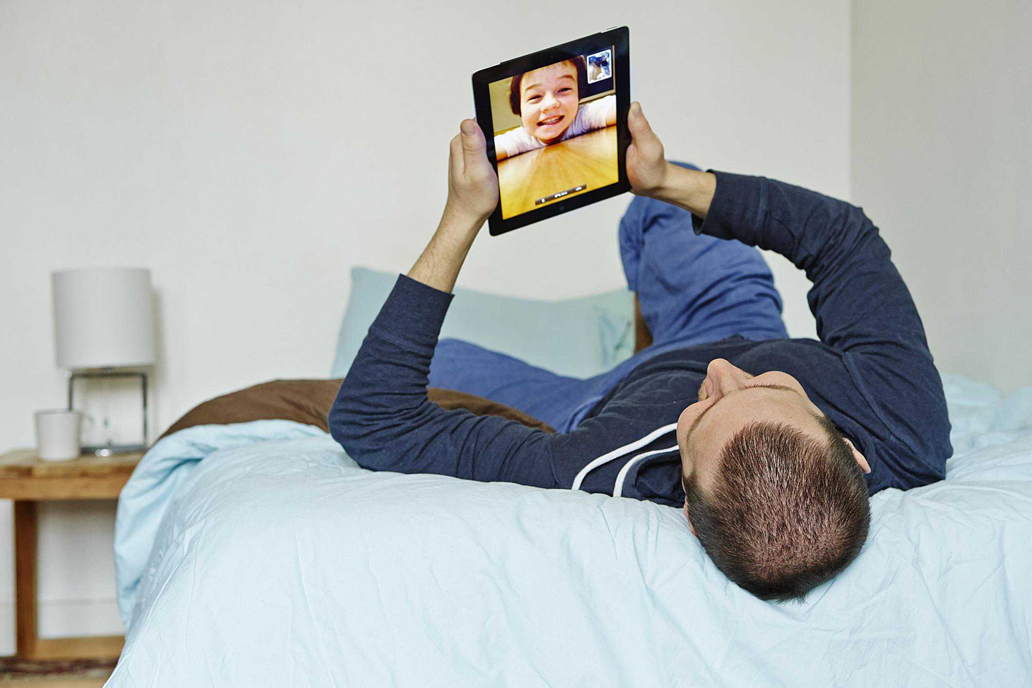 Man die iPad gebruikt om te videochatten met jonge jongen