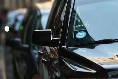 Een foto van een geparkeerde auto van een Uber-chauffeur met de Uber-sticker in de voorruit.