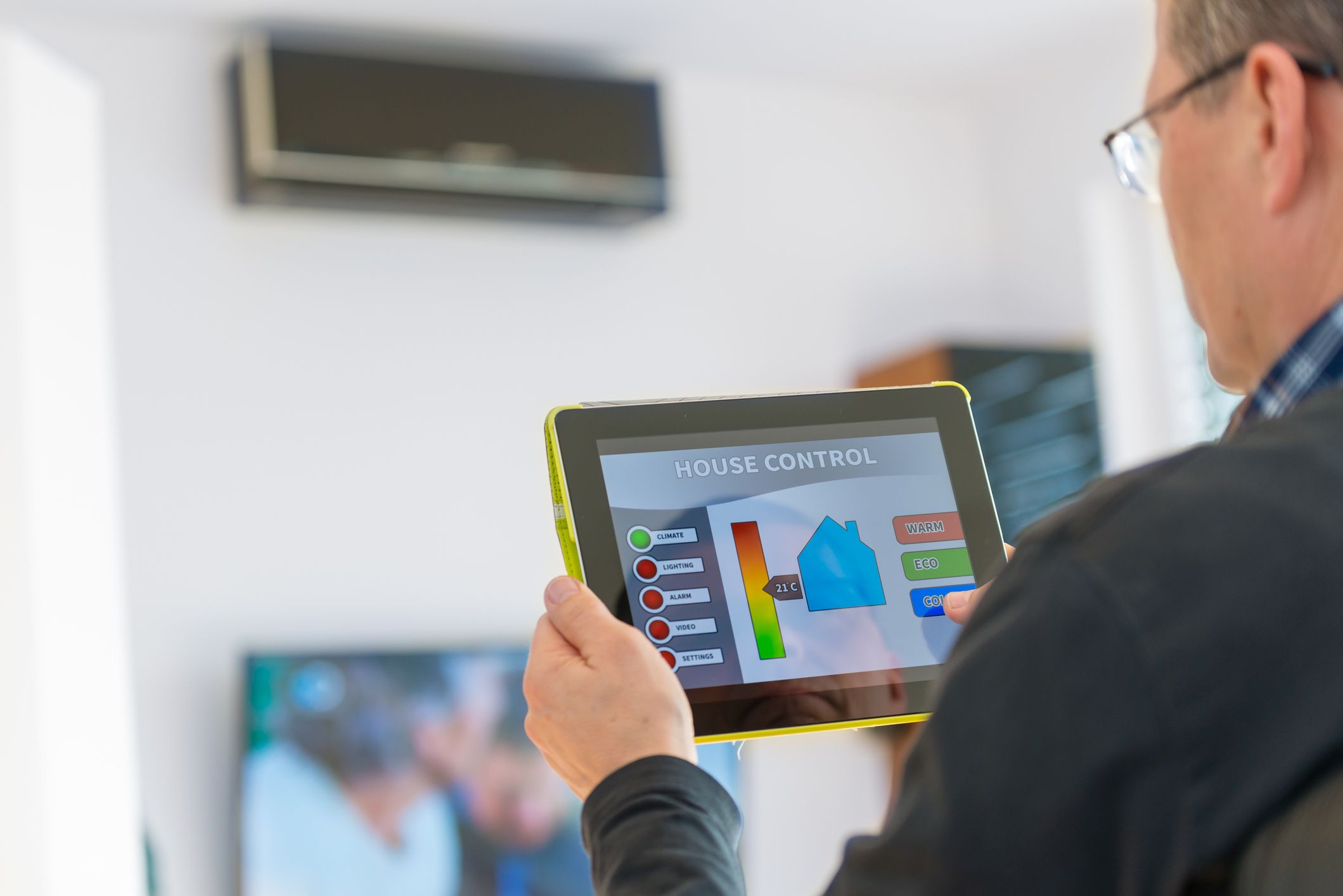 Huiseigenaar die een tablet gebruikt om de slimme airconditioner in huis te bedienen