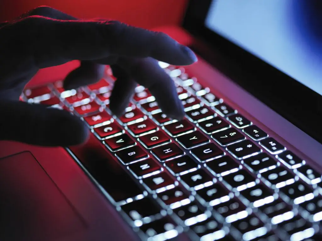 a dark mystery hand typing on a laptop computer at night 685007437 5b248818ba61770036e0cbf2