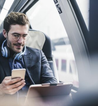 businessman in train with cell phone headphones and tablet 932633170 5b9e7c58c9e77c0050941bea