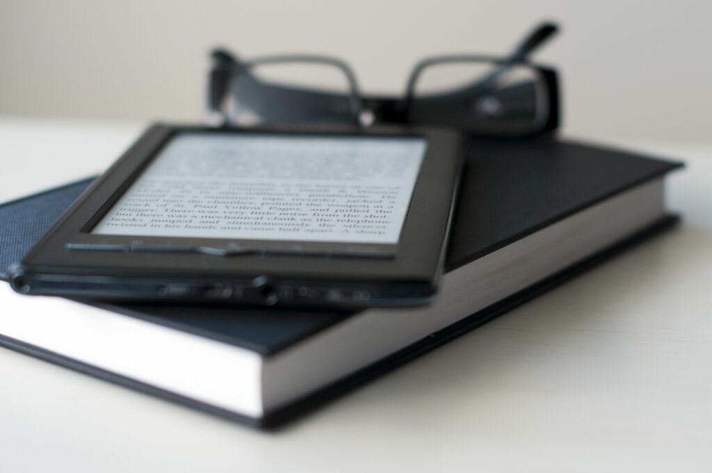 e reader and book with reading glasses 147192719 591099cf5f9b586470ff2fc6