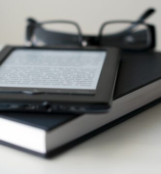 e reader and book with reading glasses 147192719 591099cf5f9b586470ff2fc6