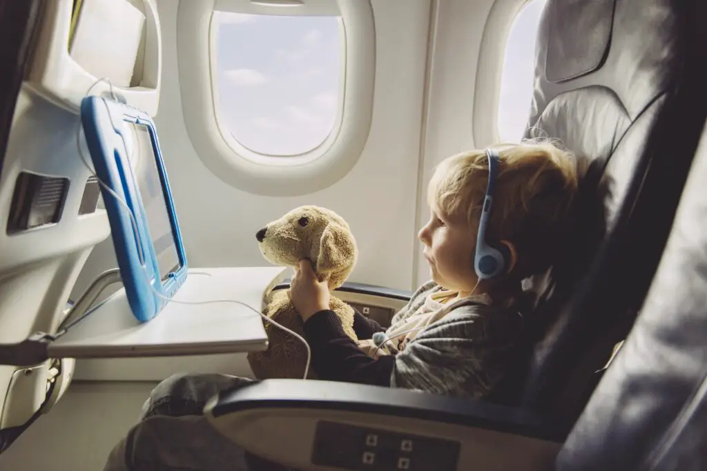 little boy sitting on an airplane watching something on digital tablet 588493599 5c3ab05246e0fb00015be86f