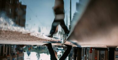 low section of man walking on road with reflection in puddle 758488257 5c2015b846e0fb0001c48d87