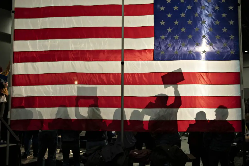 people silhouetted against an american flag 1214707683 405991a5634c4e6b976c66b0a1019a09