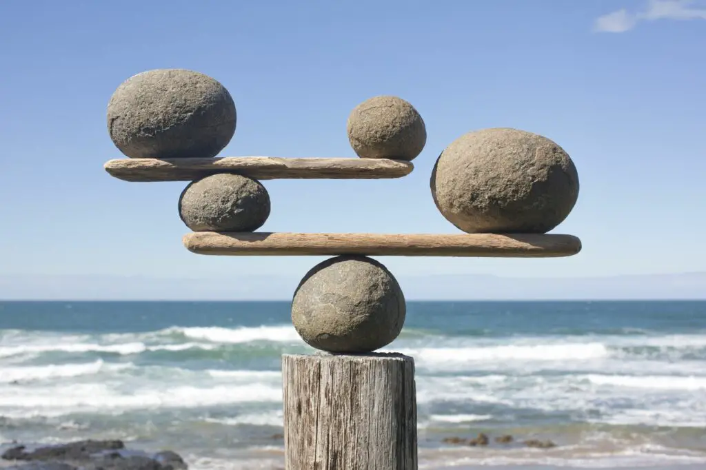 rocks balancing on driftwood sea in background 153081592 591bbc3f5f9b58f4c0b7bb16