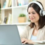 woman with headphones and laptop at home 1280611332 e84e8ba7fbea449b82ced11c31cf7160