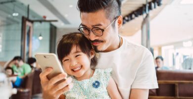 young dad using smartphone with little daughter 581036187 5b27338d8e1b6e003656e8f2