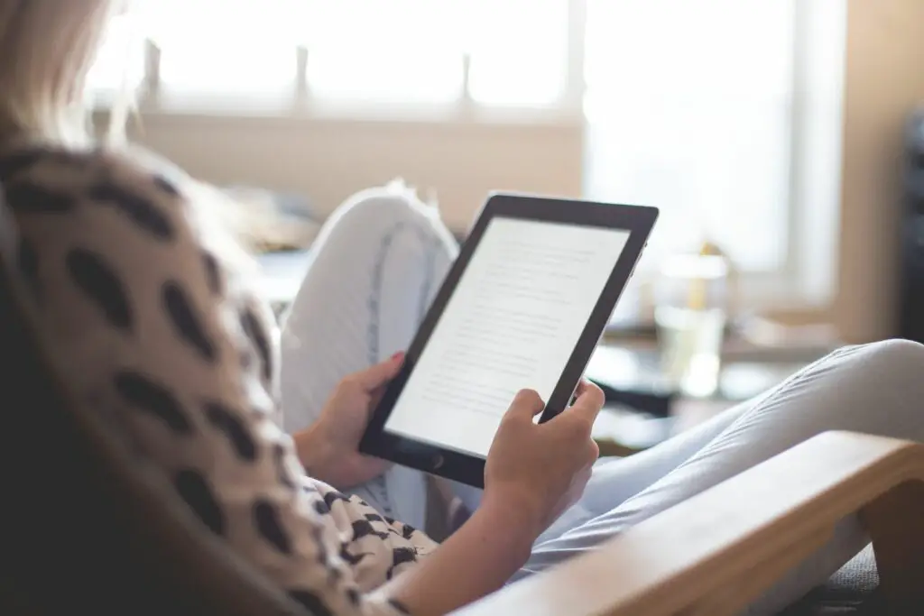 young woman reading a book on her ipad picjumbo com 59a81d1f9abed5001110d00d