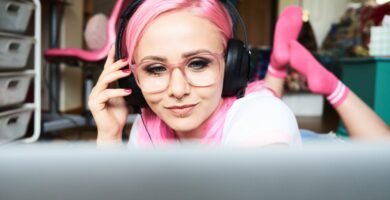 young woman with pink hair listening to music via laptop at home 769729445 5a36dfedaad52b0036c213f3 5c057421c9e77c0001694fb9