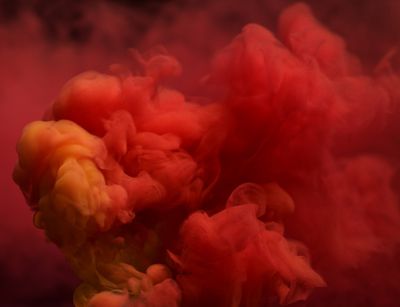 Rood gekleurde rook die opstijgt en zich vermengt tot prachtige abstracties