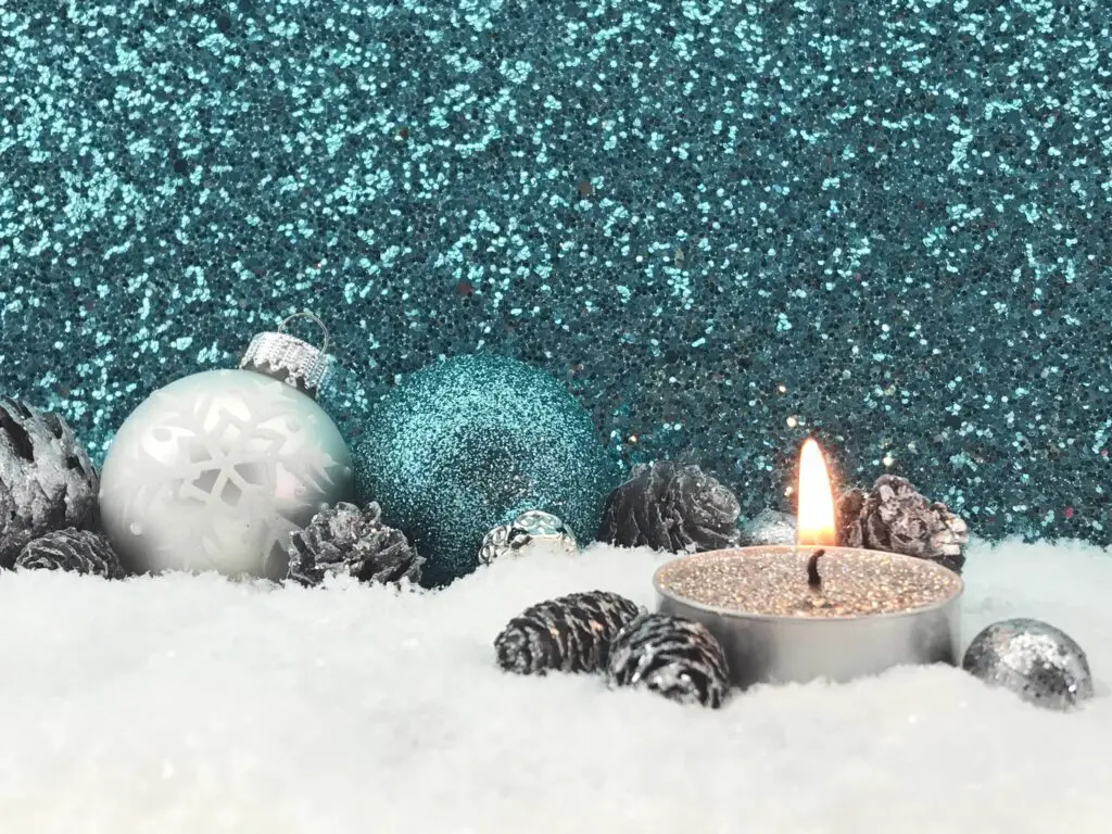 lit candle with christmas decoration on fake snow against glittering wall 758535587 5b480cf346e0fb0037182125