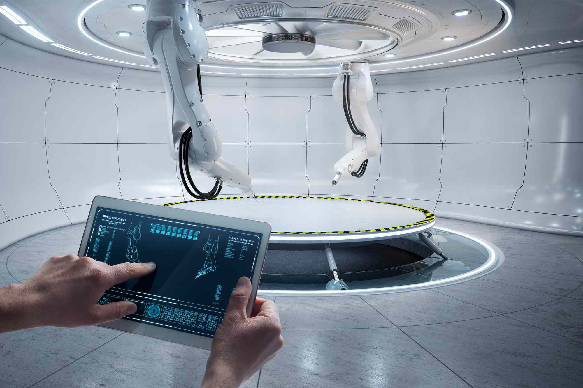 Twee robotarmen in een laboratorium die worden bestuurd door iemand die een tablet gebruikt.