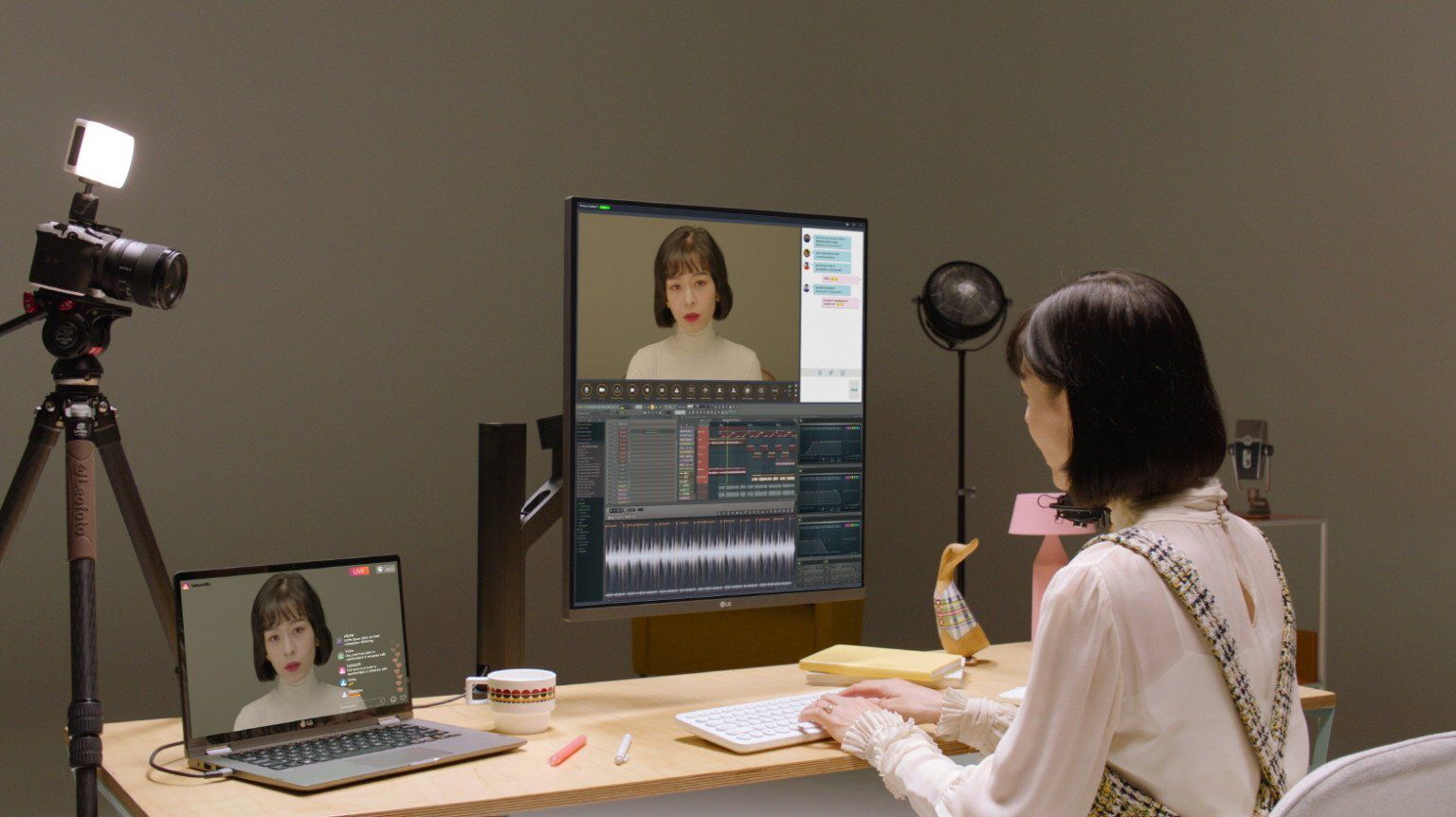 Vrouw die LG DualUp Monitor gebruikt, evenals een laptop en webcam