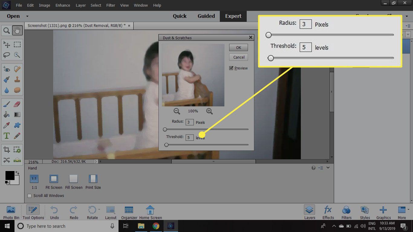 Een screenshot van Photoshop Elements met de schuifregelaars Radius en Threshold in het venster Dust & Scratches gemarkeerd