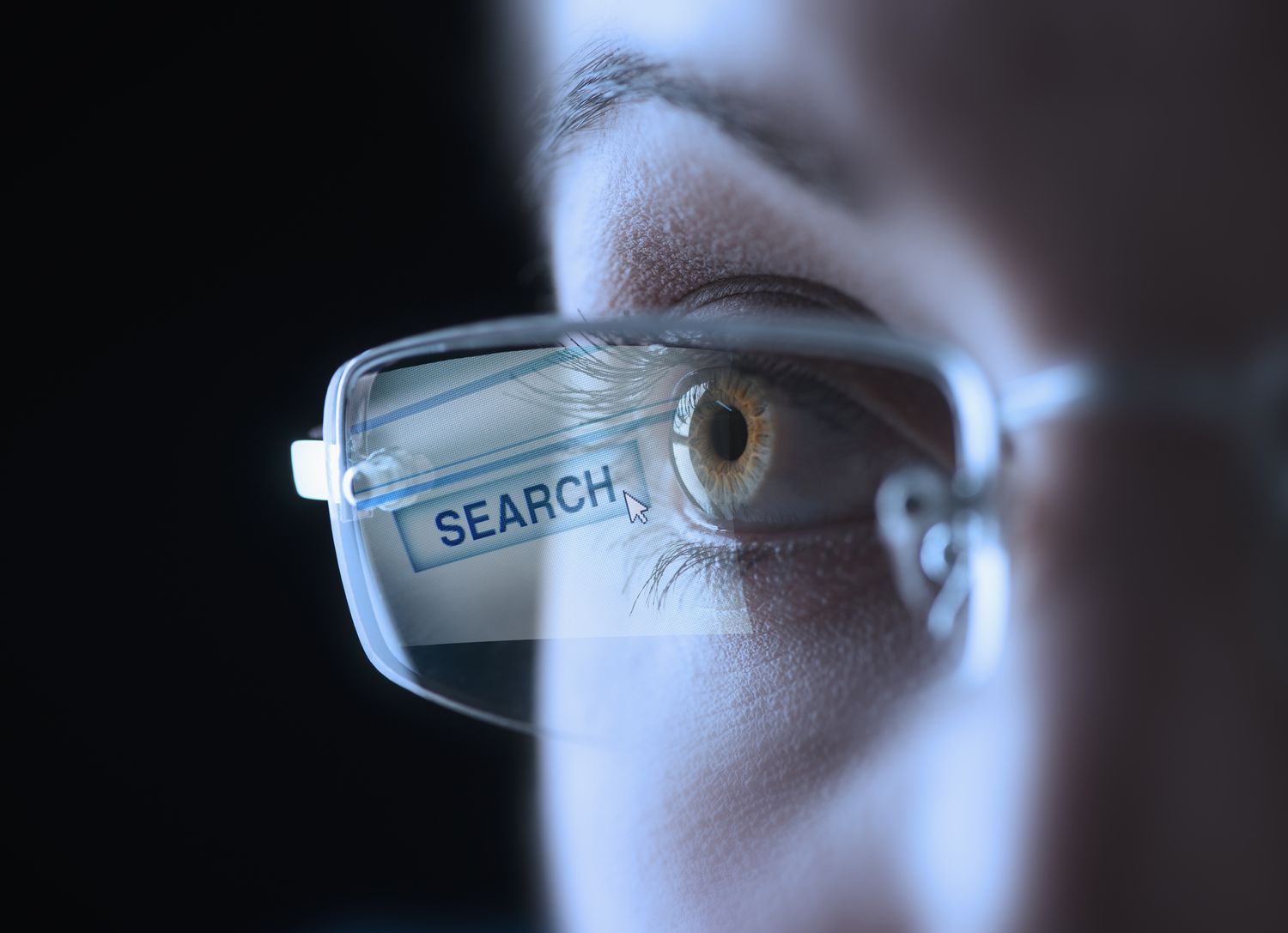 Coseup van een menselijk oog, met een bril met een zoekknop die op de lens reflecteert.